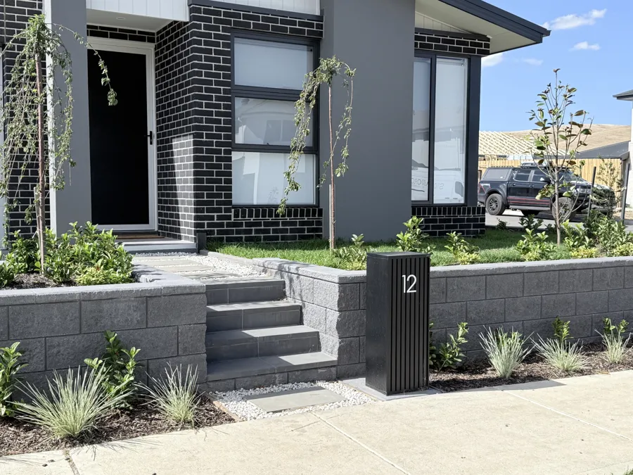 Engineered block retaining wall with front steps and planted garden bed